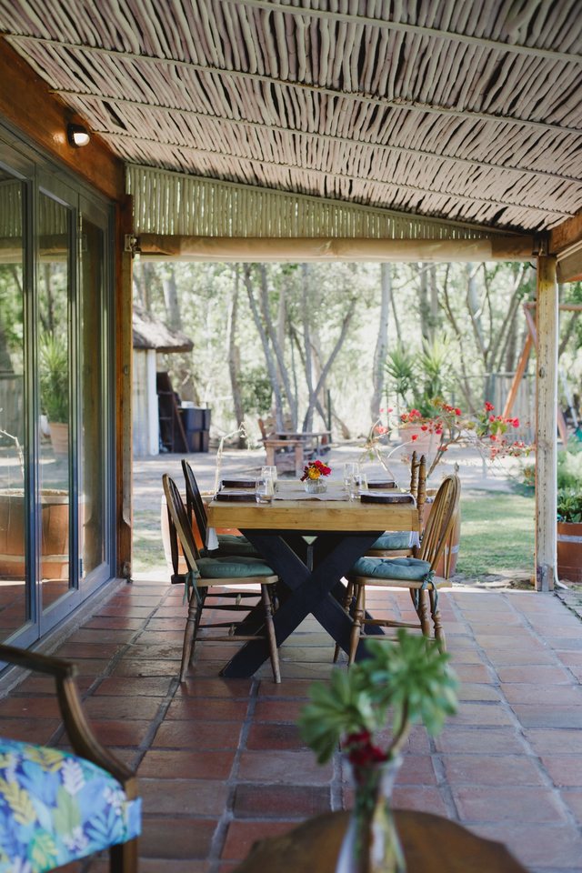 A table set with flowers on Melfort’s shaded veranda, overlooking the garden